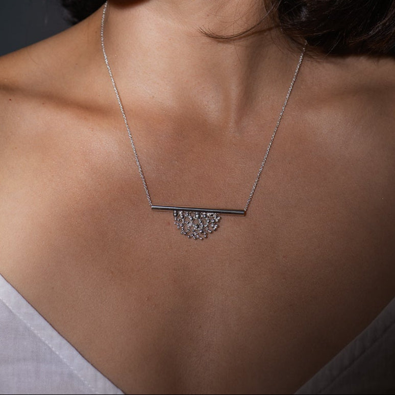 Collier tube avec demi-lune de granules en argent sterling porté au cou.