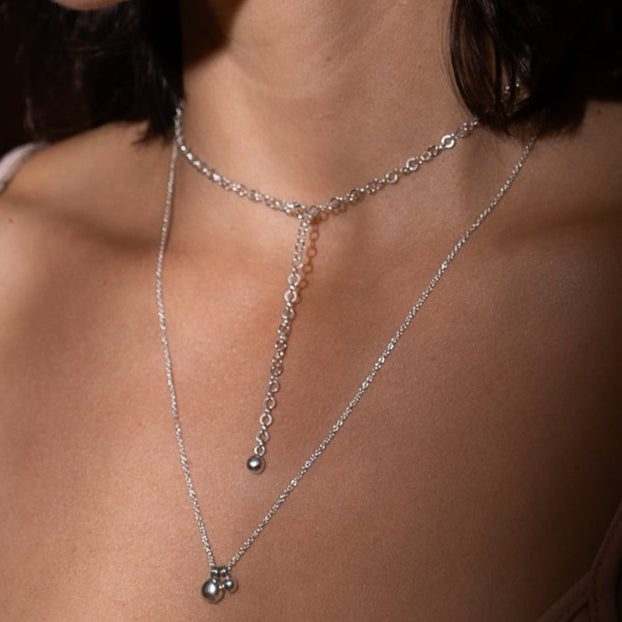 Collier chaîne ronde en argent sterling avec breloque porté au cou.