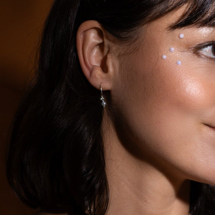 Anneaux asymétriques en argent sterling avec perles naturelles portés à l’oreille.