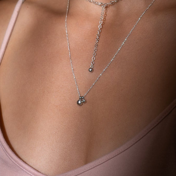 Collier en argent récupéré avec pendentifs granules porté au cou.