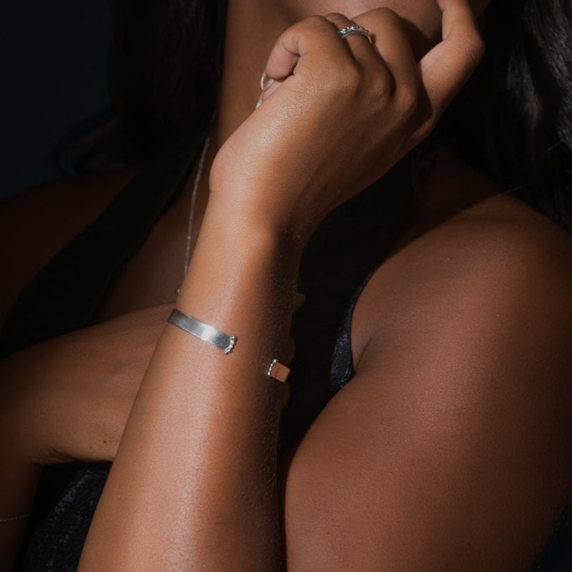 Bracelet rigide ouvert en argent sterling porté au poignet.