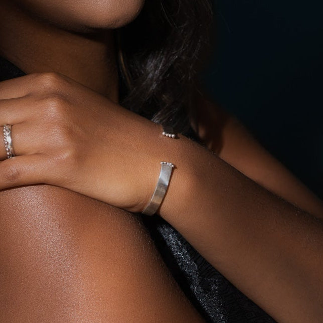 Bracelet rigide ouvert en argent sterling porté au poignet.