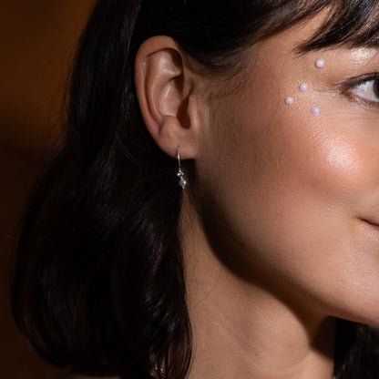 Anneaux asymétriques en argent sterling avec perles naturelles portés à l’oreille.